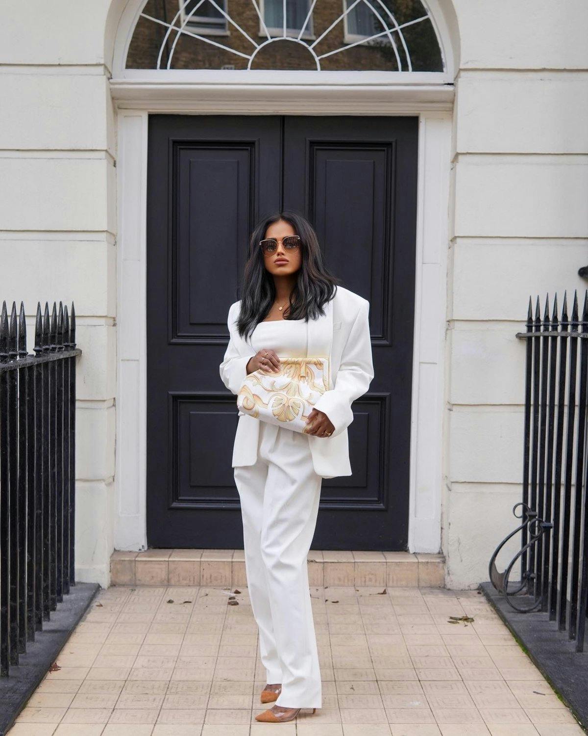 Sachini wearing a white suit and a fendance bag