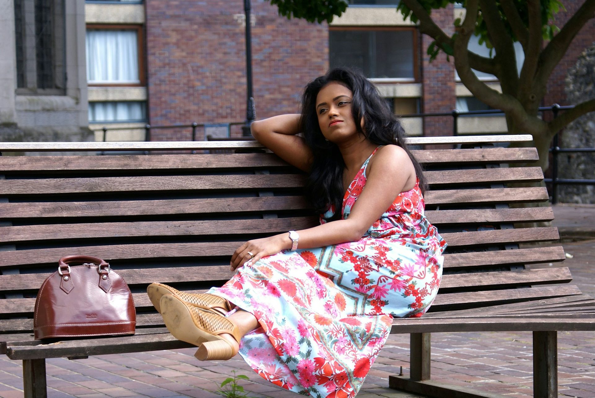 Sachini wearing a colourful dress setting on a bench